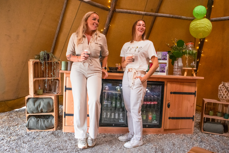 Twee collega's houden een theepauze in de tipi