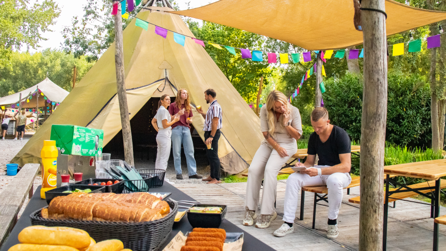 Collega's staan buiten te kletsen voor een tipi