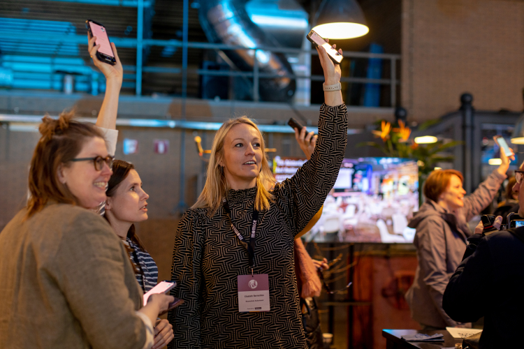 Mensen met hun telefoon in de lucht tijdens de Ice Breaker activiteit van The Box Company