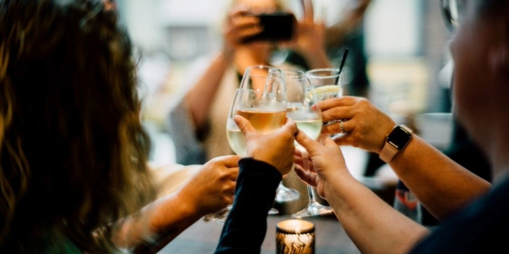 Gasten die samen proosten met glazen wijn tijdens een informele borrel in restaurant KonneKt van Conferentiehotel Kontakt der Kontinenten.