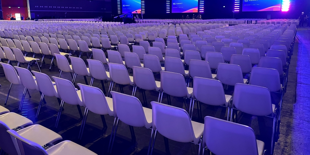 Grote zaalopstelling met honderden witte stoelen voor een congres of evenement, professioneel ingericht door Accuraat Verhuur.