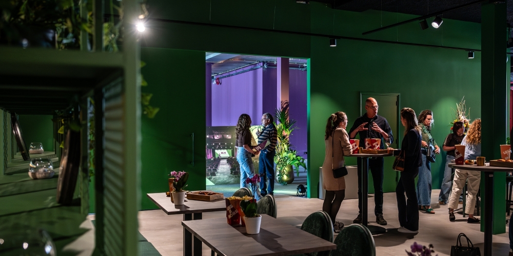 Doorkijk naar paarse congreszaal BIOS Zeelandhallen vanuit groene foyer