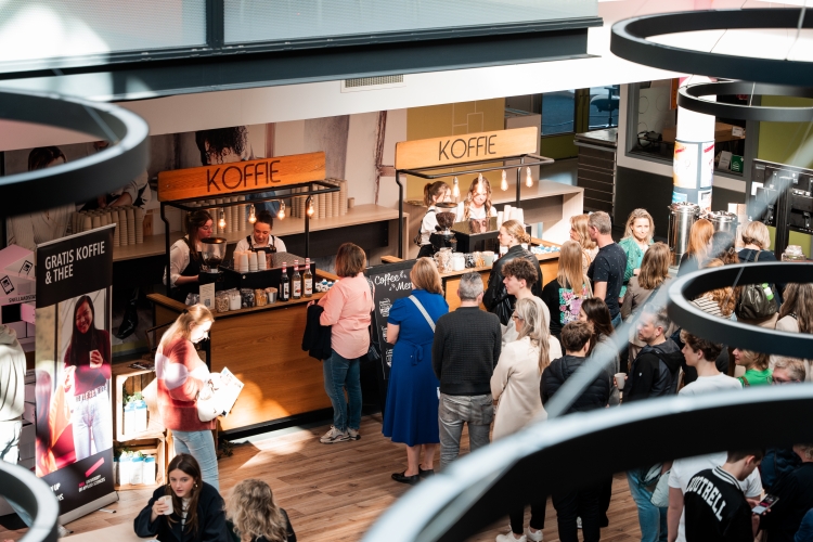 Twee mobiele koffiebars met barista's op een zakelijk evenement