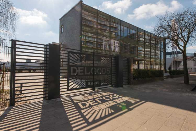 Voorzijde van de Loods en toegang tot de parkeer- en laadfaciliteiten via de poort