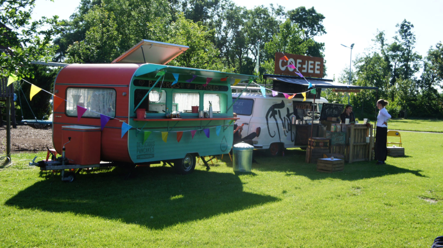 Foodtrucks op het veld bij DE TENT