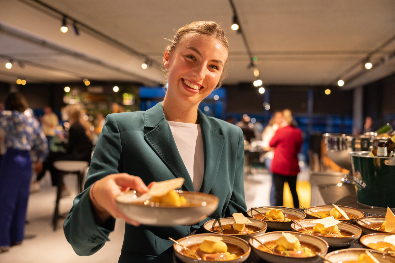Cateringmedewerker serveert gerechtjes