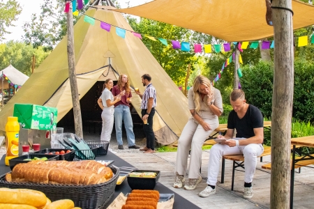 Collega's staan buiten te kletsen voor een tipi