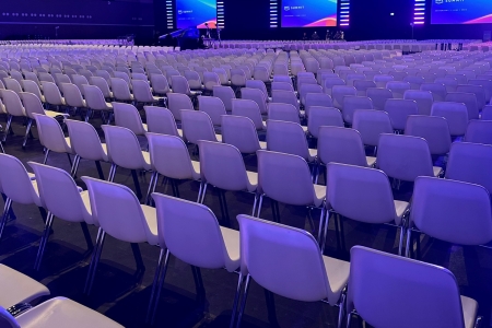 Grote zaalopstelling met honderden witte stoelen voor een congres of evenement, professioneel ingericht door Accuraat Verhuur.