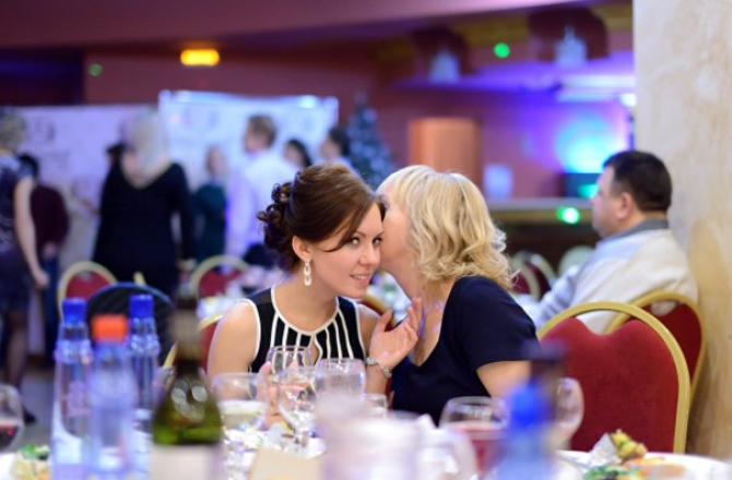 Dame die in oor fluistert bij andere dame