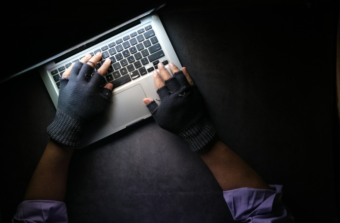 Laptop met handen in handschoenen
