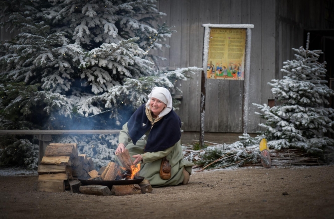 Vrouw bij vuur in winteromgeving