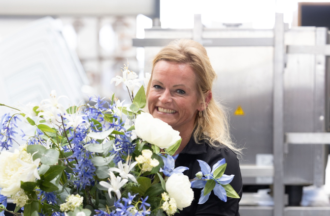 Vrouw met grote vaas met bloemen