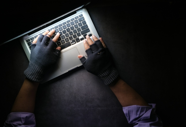 Laptop met handen in handschoenen
